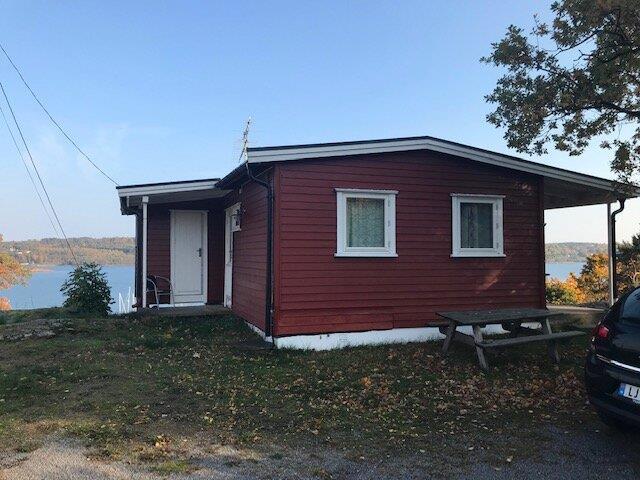Rød hytte ved sjøen. - Klikk for stort bilde