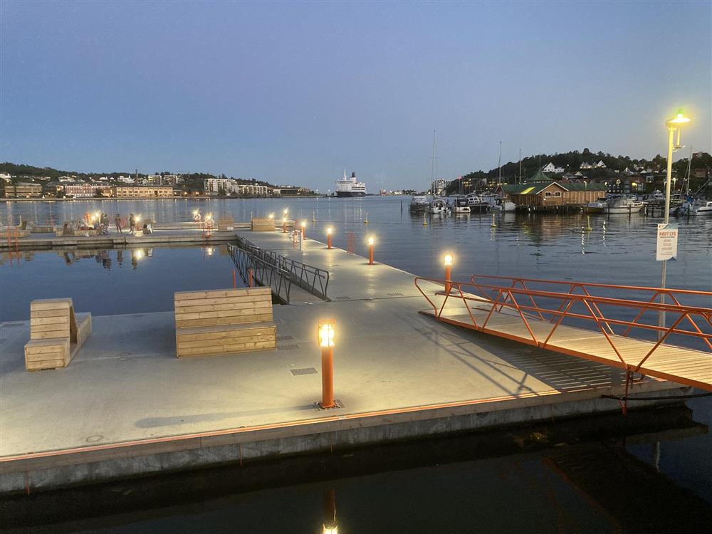 Flytebrygger i sjø med mulighet for bad og opphold, sikt ut fjorden og til historisk badehus - Klikk for stort bilde