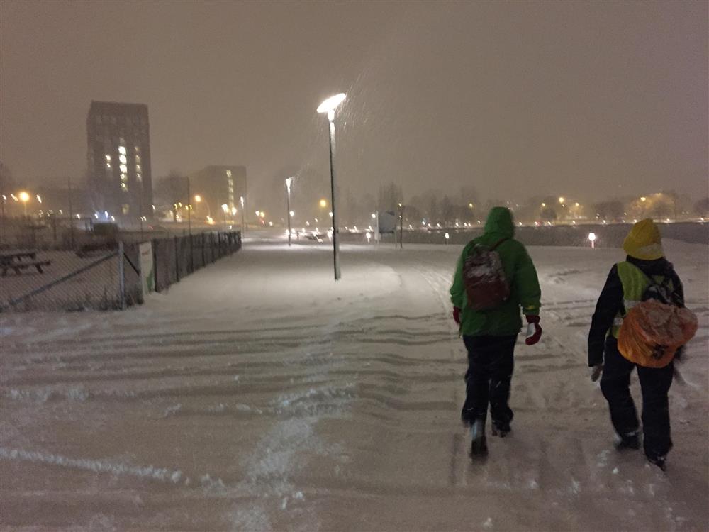 Vinterkveld med snøvær, folk på tur, sjø - Klikk for stort bilde